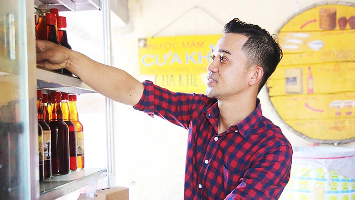 Anh Võ Nguyên Tùng đang chuẩn bị nước mắm, đặc sản của địa phương giới thiệu đến du khách.