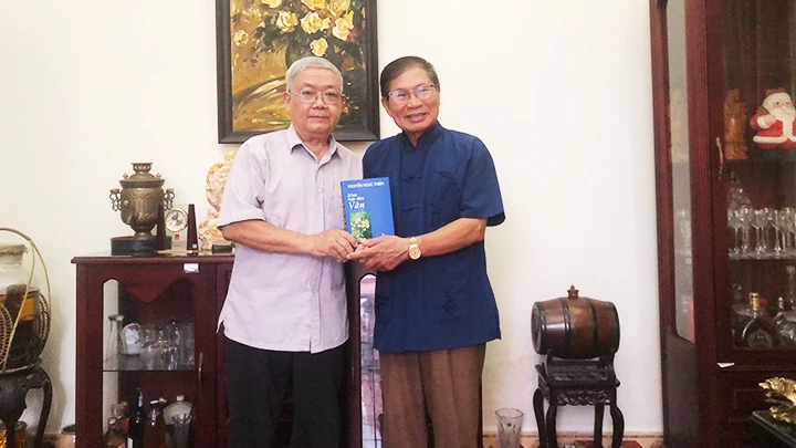 PGS, TS Nguyễn Ngọc Thiện (bên trái) tặng cuốn sách - Khúc hợp đàn văn - cho nhà thơ Lê Tuấn Lộc - tác giả bài viết.