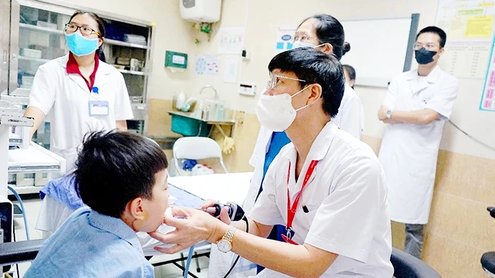 PGS, TS Phạm Tuấn Cảnh khám lại cho bệnh nhi. Ảnh: BỆNH VIỆN CUNG CẤP