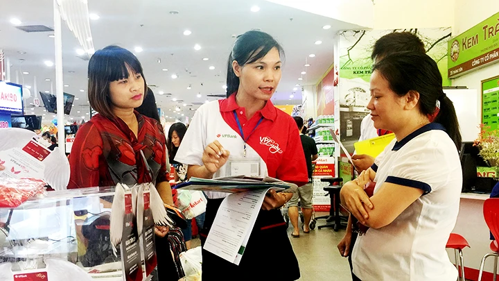 Khách hàng tìm hiểu về tiện ích của thẻ tín dụng. Ảnh: NAM HẢI
