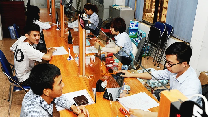 Người lao động làm thủ tục nhận quyền lợi bảo hiểm tại Trung tâm Dịch vụ việc làm Hà Nội. Ảnh: BẮC HẢI