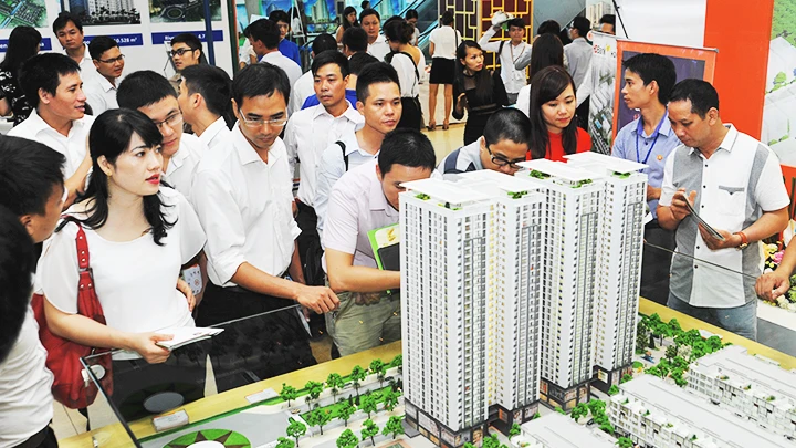Khách hàng tìm hiểu thông tin dự án chung cư tại sàn giao dịch. Ảnh: ANH NGUYỆT