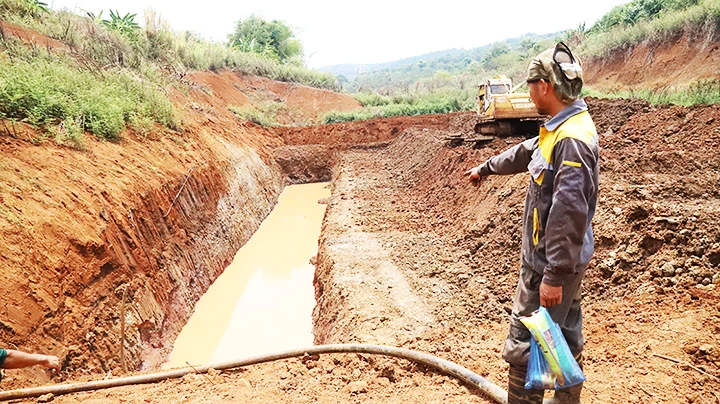 Gia đình anh Y Oen Niê ở buôn Ea Káp, xã Ea Sin, huyện Krông Búk cùng các hộ dân góp tiền thuê xe múc về múc hồ dưới lòng hồ đã khô cạn để tìm nước cứu cây trồng.