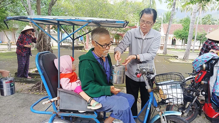 Sơ Lucia Hoàng Thị Mỹ Dung phát cơm miễn phí cho các bệnh nhân cao tuổi tại làng phong.