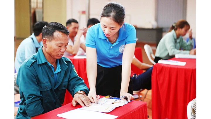 Cán bộ bảo hiểm xã hội tỉnh Yên Bái hướng dẫn người dân tham gia.