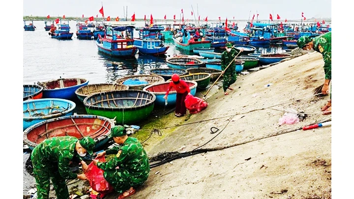 Người dân và lính biên phòng thu gom rác dọc bờ biển.