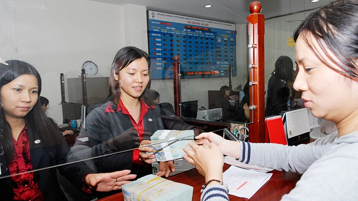 Trong giai đoạn chưa triển khai kế hoạch tái đầu tư gửi tiền vào ngân hàng là lựa chọn của nhiều doanh nghiệp. Ảnh: NAM ANH