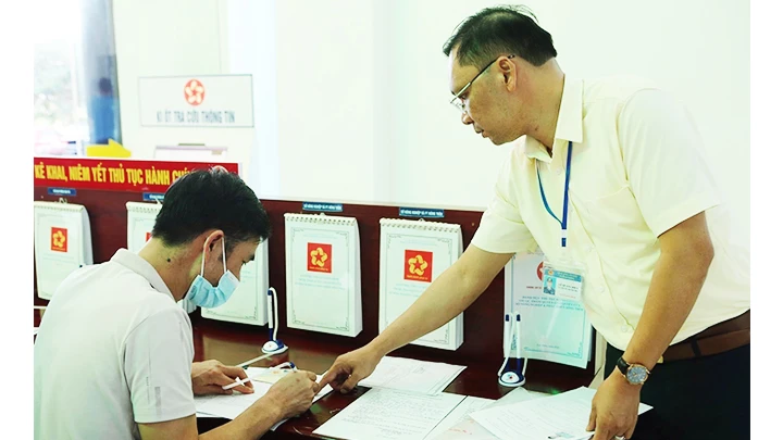Cán bộ Văn phòng UBND tỉnh Lai Châu hướng dẫn người dân thực hiện thủ tục hành chính. 