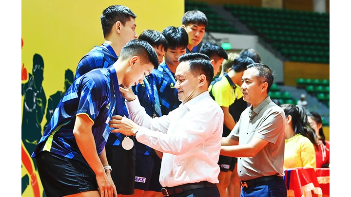 Phó Tổng Biên tập Báo Nhân Dân Phan Văn Hùng và Chủ tịch Liên đoàn Bóng bàn Việt Nam Nguyễn Xuân Vũ trao huy chương và cúp cho các đội đoạt giải tại nội dung đồng đội nam.