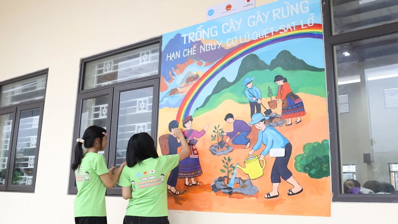 Các em học sinh Trường phổ thông dân tộc nội trú Trung học cơ sở và Trung học phổ thông huyện Bảo Thắng, tỉnh Lào Cai vẽ tranh tường.