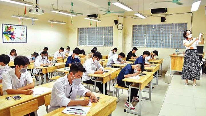 Giám thị hướng dẫn cách làm bài thi môn Toán tại điểm thi Trường THPT Nguyễn Gia Thiều, thành phố Hà Nội. (Ảnh: MỸ HÀ)