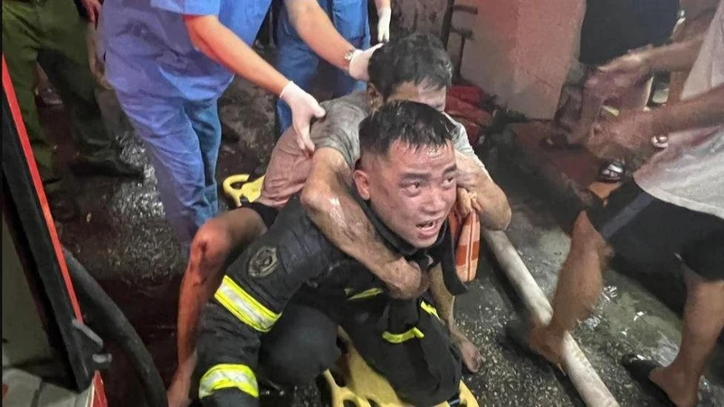 Cảnh sát phòng cháy chữa cháy và cứu nạn cứu hộ đưa người dân thoát khỏi đám cháy.