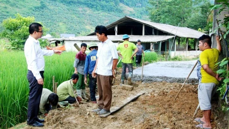 Bí thư Đảng ủy thị trấn Phong Hải Vũ Trung Dũng (áo trắng, bìa trái) kiểm tra đổ bê tông đường giao thông đến hộ gia đình ở thôn Ải Nam, chủ yếu là đồng bào dân tộc thiểu số sinh sống.