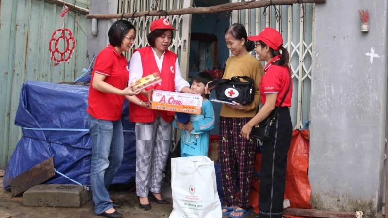 Các tình nguyện viên Hội Chữ thập đỏ trao túi sơ cứu, túi hàng cho hộ thuê trọ.
