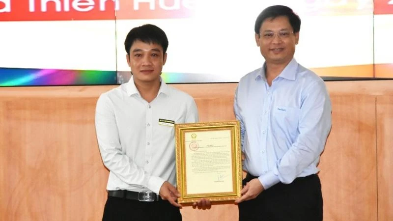 Phó Chủ tịch Thường trực UBND tỉnh Thừa Thiên Huế Nguyễn Thanh Bình (bên phải) trao Thư khen của Chủ tịch nước cho anh Tô Vũ Đồng.