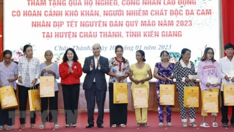 Chủ tịch nước Nguyễn Xuân Phúc tặng quà cho hộ nghèo, công nhân lao động có hoàn cảnh khó khăn, người nhiễm chất độc da cam trên địa bàn. (Ảnh: Thống Nhất/TTXVN)
