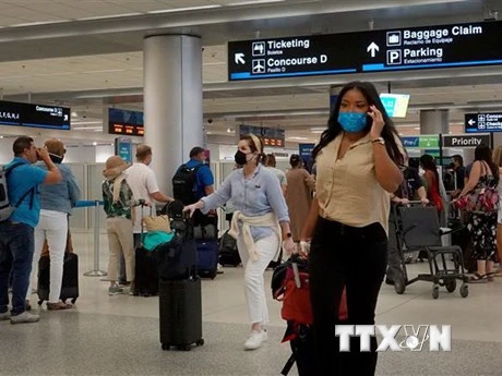 Hành khách đeo khẩu trang phòng lây nhiễm Covid-19 tại sân bay ở Miami, Florida, Mỹ. (Ảnh: AFP/TTXVN)
