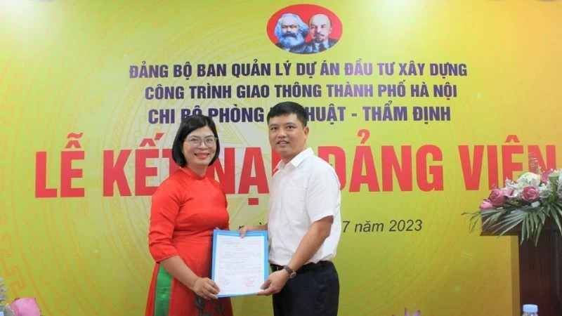 Bí thư Chi bộ Phòng Kỹ thuật-Thẩm định (Ban Quản lý dự án đầu tư xây dựng công trình giao thông thành phố Hà Nội) trao Quyết định kết nạp đảng cho đồng chí Bùi Thị Phương Ngọc. Ảnh: Linh Nguyễn