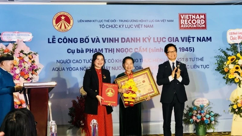 Tổ chức Kỷ lục Việt Nam (VietKings) trao bằng chứng nhận cho cụ bà Phạm Thị Ngọc Cầm. (Ảnh: Phương Hà/TTXVN)