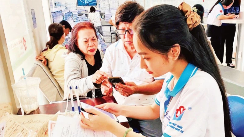 Tình nguyện viên Trung tâm Phát triển khoa học và công nghệ trẻ (Thành đoàn TP Hồ Chí Minh) hỗ trợ người dân làm các thủ tục hành chính.
