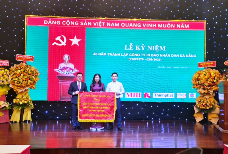 Tổng Biên tập Báo Nhân Dân Lê Quốc Minh trao bức trướng với dòng chữ “Đoàn kết- Đổi mới-Phát triển bền vững” tặng tập thể lãnh đạo, nhân viên Công ty In Báo Nhân Dân Đà Nẵng.