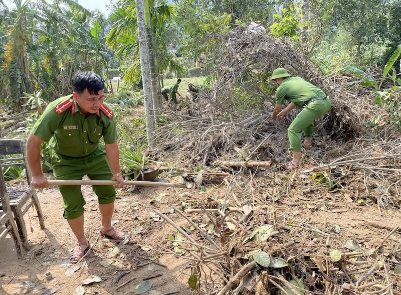 Thượng úy Bùi Văn Hoàng cùng cán bộ chiến sỹ Công an xã Hoà Bắc giúp dân dọn nhà sau bão lũ. Ảnh Công an xã Hoà Bắc