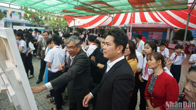 Nghệ sĩ nhiếp ảnh Ông Văn Sinh giới thiệu các tác phẩm của mình với học sinh và người dân xã Hòa Bắc, huyện Hòa Vang, thành phố Đà Nẵng. (Ảnh: ANH ĐÀO)