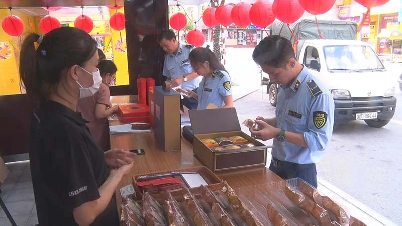 Cán bộ Cục Quản lý thị trường tỉnh Hà Nam kiểm tra nguồn gốc, xuất xứ của các loại bánh trung thu được bày bán trên thị trường.