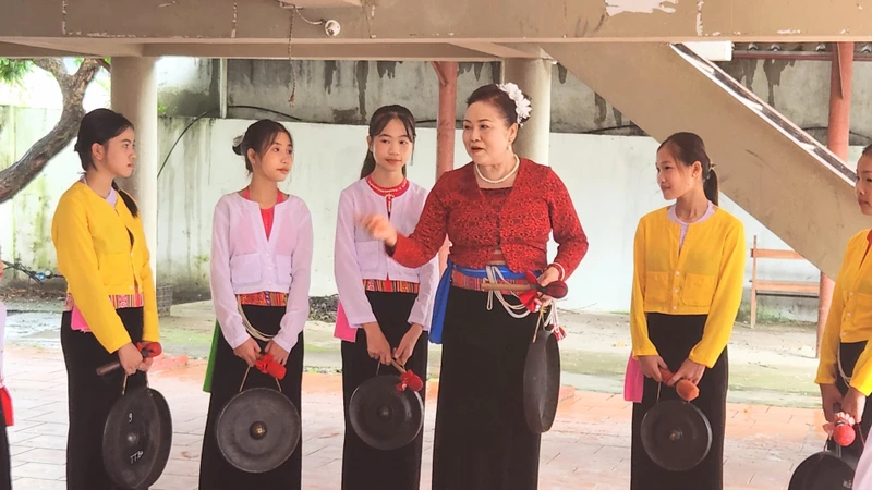 Bà Dung đang dạy Chiêng Mường cho các cháu.