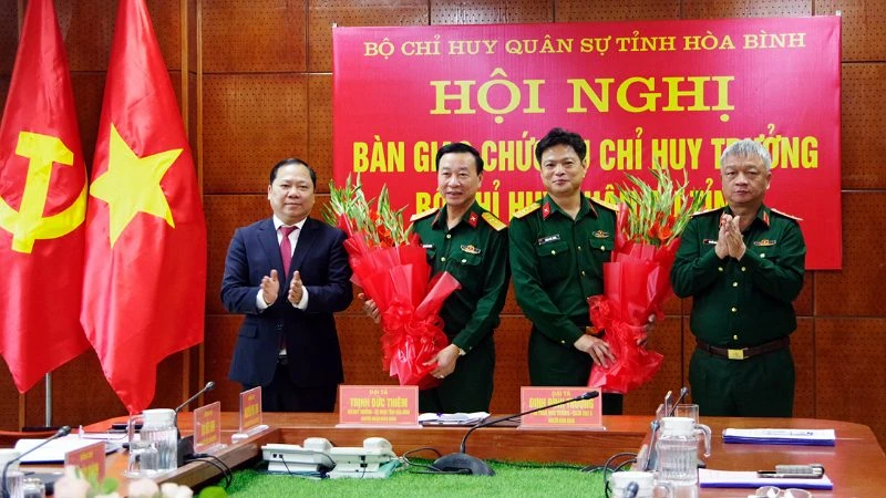 Trung tướng Nguyễn Quang Ngọc, Tư lệnh Quân khu 3 (phải) và đồng chí Nguyễn Phi Long, Bí thư Tỉnh ủy Hòa Bình (trái) tỉnh tặng hoa chúc mừng các đồng chí Đinh Đình Trường (thứ 2 từ trái sang) và Trịnh Đức Thiêm (thứ 2 từ phải sang) nhận nhiệm vụ mới.
