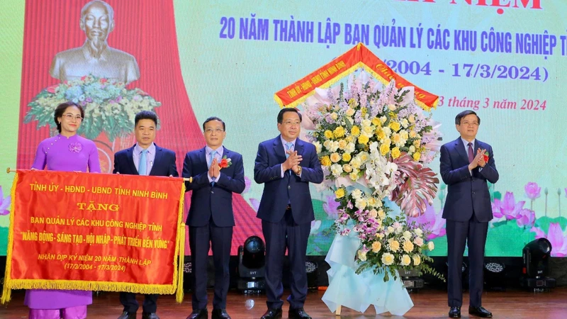 Đồng chí Bí thư Tỉnh ủy Ninh Bình Đoàn Minh Huấn đã trao bức trướng với dòng chữ "Năng động-sáng tạo-hội nhập-phát triển bền vững" và tặng hoa cho Ban Quản lý các khu công nghiệp tỉnh. (Ảnh: ANH TUẤN)
