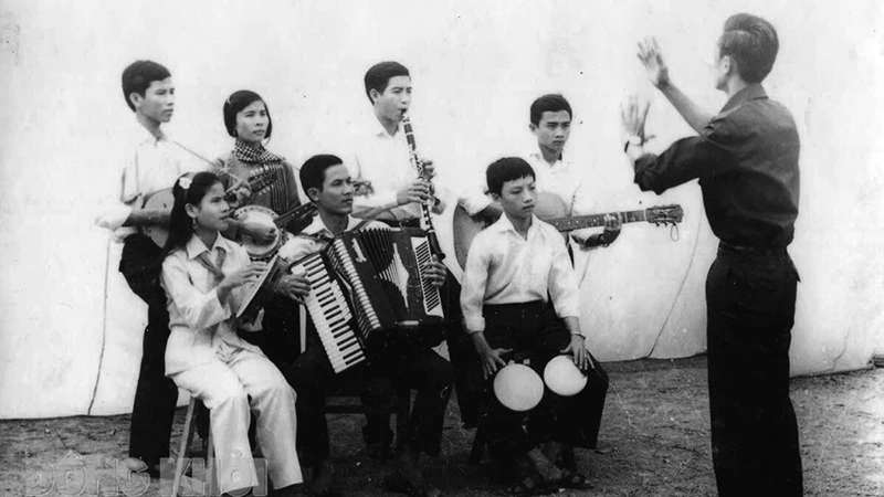 Nhạc sĩ Lan Phong (đứng) chỉ huy anh chị em Đoàn Văn công giải phóng hòa tấu bài nhạc “Giải phóng miền Nam”. Ảnh: Tư liệu 
