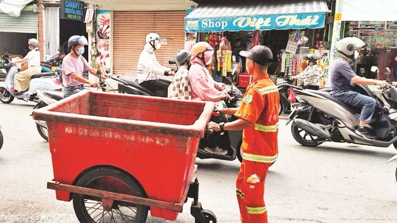 Công nhân vệ sinh thu gom và vận chuyển rác thải ở Quận 1.