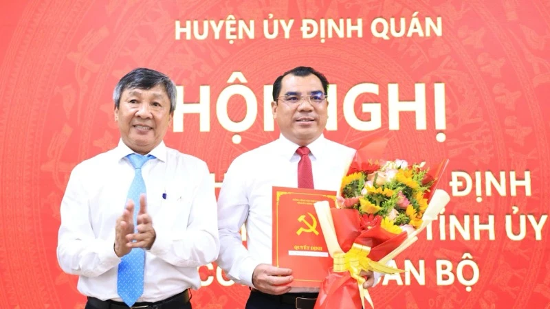 Phó Bí thư Thường trực Tỉnh ủy Hồ Thanh Sơn trao quyết định và tặng hoa chúc mừng tân Bí thư Huyện ủy Định Quán.