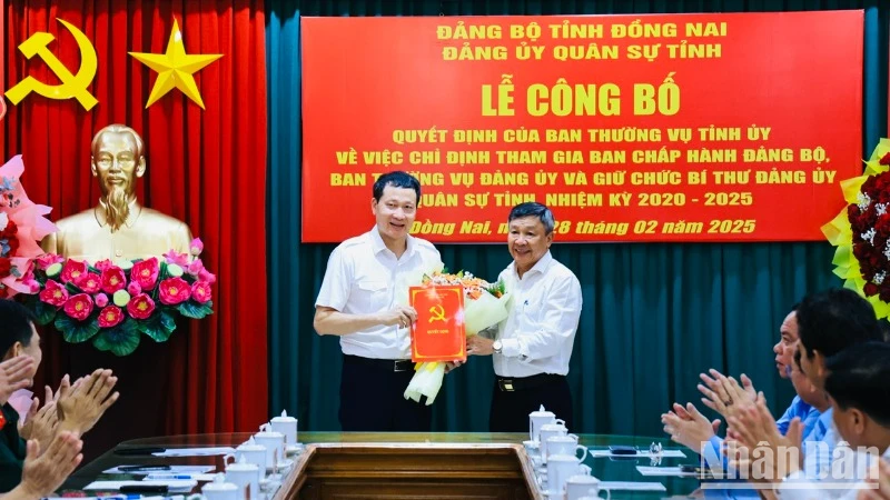 Phó Bí thư Thường trực Tỉnh ủy Đồng Nai trao quyết định và tặng hoa chúc mừng đồng chí Vũ Hồng Văn, Bí thư Tỉnh ủy, Bí thư Đảng ủy Quân sự tỉnh.