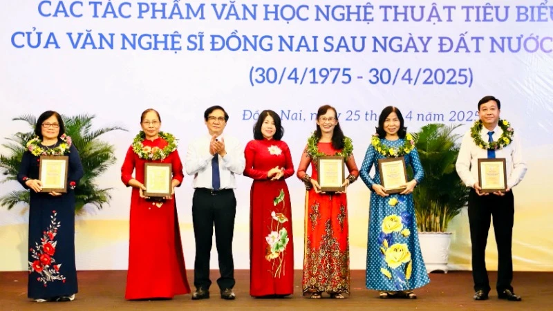 Phó Chủ tịch HĐND tỉnh Đồng Nai Hoàng Thị Bích Hằng và Phó Chủ tịch UBND tỉnh Nguyễn Sơn Hùng trao biểu trưng tôn vinh cho đại diện gia đình các văn nghệ sĩ.