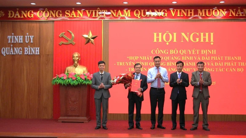 Bí thư Tỉnh ủy Quảng Bình Lê Ngọc Quang (áo xanh) trao quyết định cho Ban biên tập Báo và Đài Phát thanh - Truyền hình Quảng Bình. 