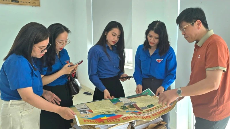 Các đoàn viên thanh niên tỉnh Quảng Bình hào hứng với phụ san đặc biệt của Báo Nhân Dân.