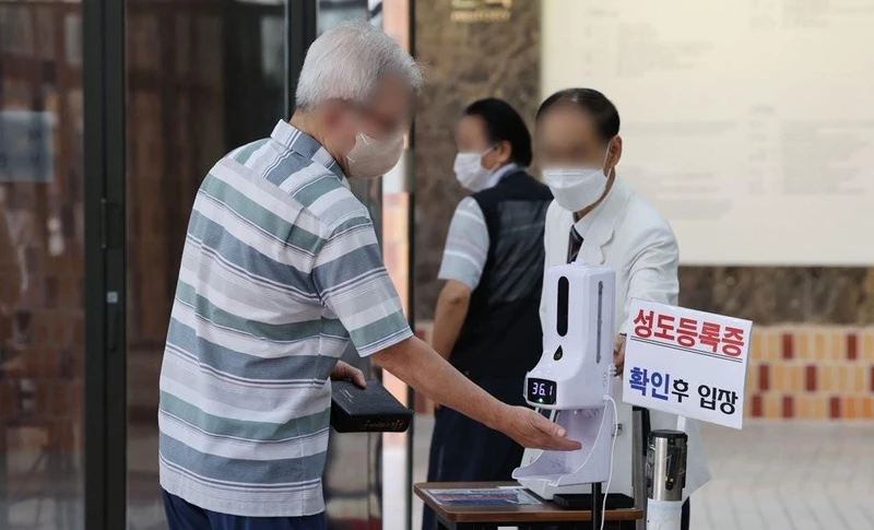 Kiểm tra thân nhiệt trước khi vào nhà thờ ở Seoul, Hàn Quốc, ngày 17/7/2022. (Ảnh: Yonhap)
