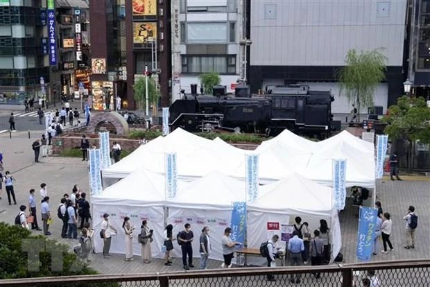 Người dân xếp hàng chờ xét nghiệm Covid-19 tại Tokyo, Nhật Bản. (Ảnh: Kyodo/TTXVN)