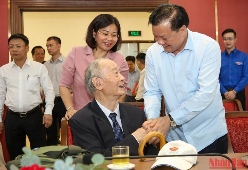 Bí thư Thành ủy Đinh Tiến Dũng thăm hỏi các đồng chí cán bộ lão thành cách mạng. (Ảnh: DUY LINH)