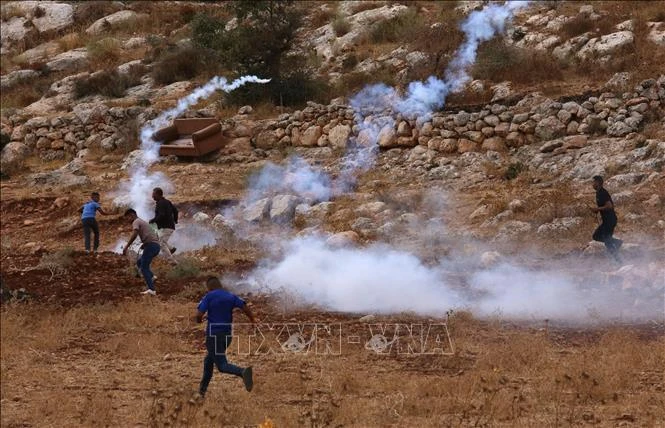 Người biểu tình Palestine ném hơi cay về phía binh lính Israel tại Nablus, Khu Bờ Tây, ngày 23/9/2022. (Ảnh: THX/TTXVN)