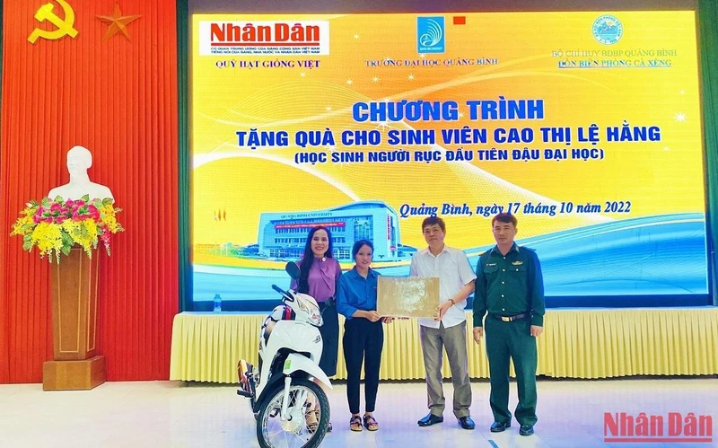 Đại diện Báo Nhân Dân và các đại biểu trao tặng xe máy, máy tính cho sinh viên Cao Thị Lệ Hằng.