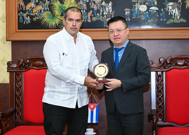 Tổng Biên tập Báo Nhân Dân Lê Quốc Minh tặng quà lưu niệm Chủ tịch hãng Thông tấn Prensa Latina Luis Enrique González Acosta. (Ảnh: DUY LINH)