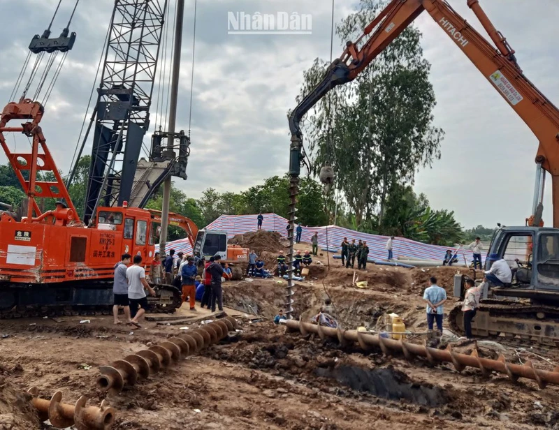 Lực lượng cứu nạn, cứu hộ tìm cách đưa bé Hạo Nam ra khỏi trụ bê-tông. (Ảnh: HỮU NGHĨA)