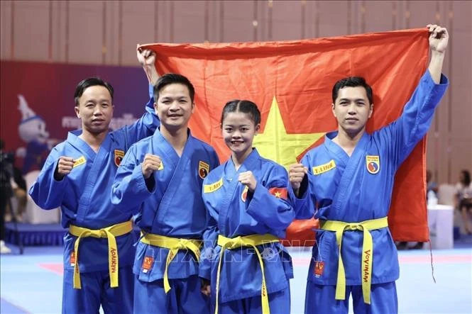 Các võ sĩ Lâm Thị Thuỳ Mỵ, Lê Toàn Trung, Đoàn Hoàng Thâm và Lâm Trí Linh ăn mừng tấm Huy chương Vàng nội dung Đa luyện vũ khí nữ của môn Vovinam. (Ảnh: TTXVN)
