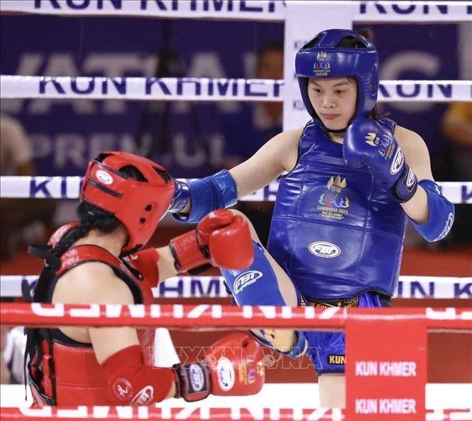 Đội Kun Khmer hứa hẹn mang về thêm nhiều tấm Huy chương Vàng quý giá trong ngày thi đấu 11/5. Trong ảnh, vận động viên Bàng Thị Mai (giáp xanh) thắng knock out Samnang Sam của nước chủ nhà Campuchia (giáp đỏ) trong trận chung kết nội dung đối kháng, hạng 60kg nữ môn Kun Khmer ngày 10/5. (Ảnh: TTXVN)