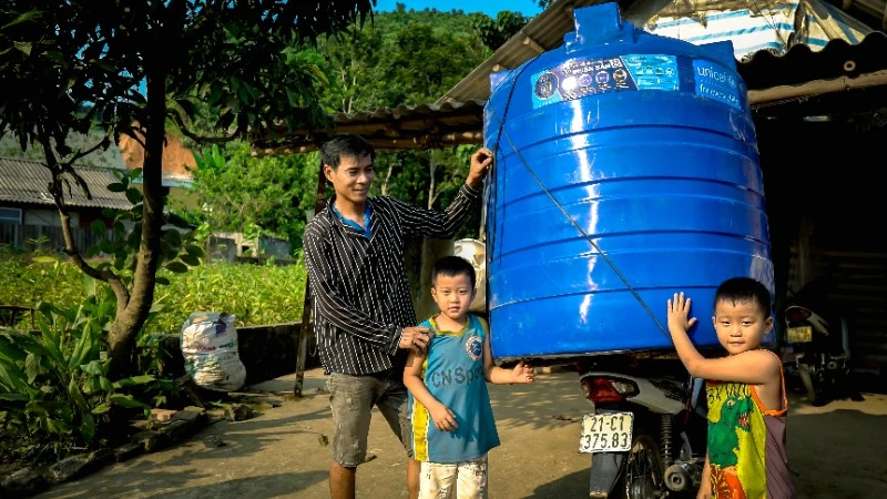 Người dân Yên Bái bị ảnh hưởng bởi bão lũ nhận thùng nước hỗ trợ từ UNICEF. (Ảnh: UNICEF Việt Nam) 