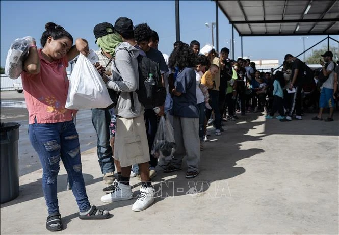 Người di cư chờ lên xe buýt để được trung chuyển khỏi bang Texas, Mỹ. (Ảnh minh họa: AFP/TTXVN)