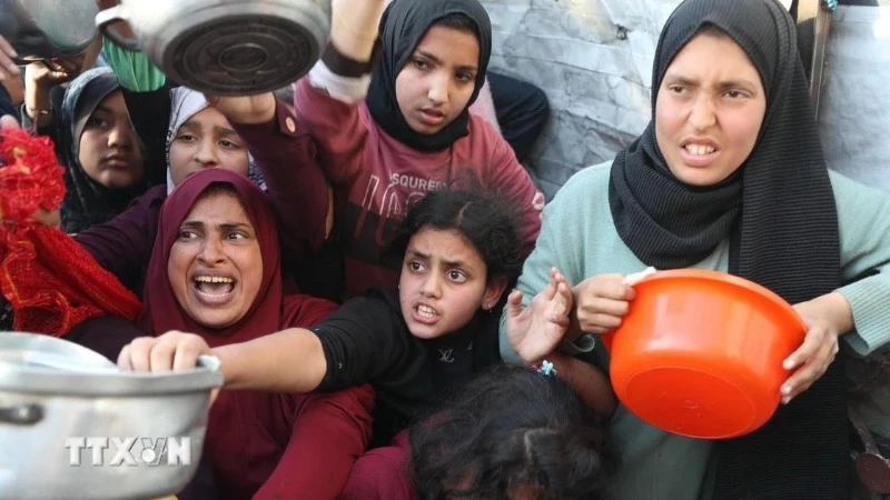 Người dân chờ nhận thức ăn cứu trợ tại Beit Lahia, miền bắc Dải Gaza ngày 22/3/2025. (Ảnh: THX/TTXVN)